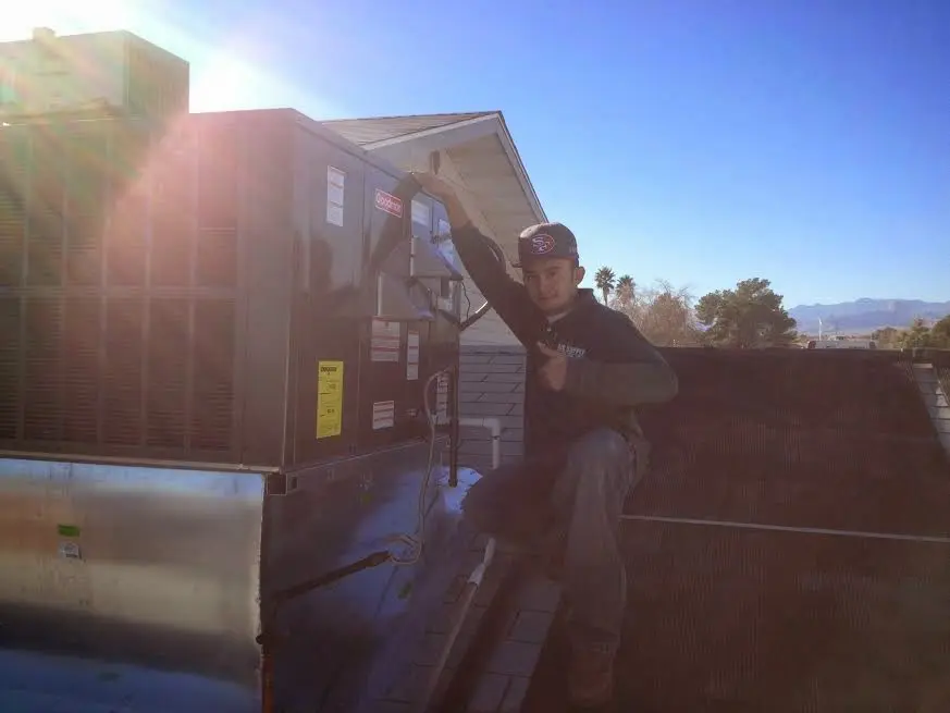 HVAC technician performing AC Tune-Up on a rooftop unit in Port St. Lucie